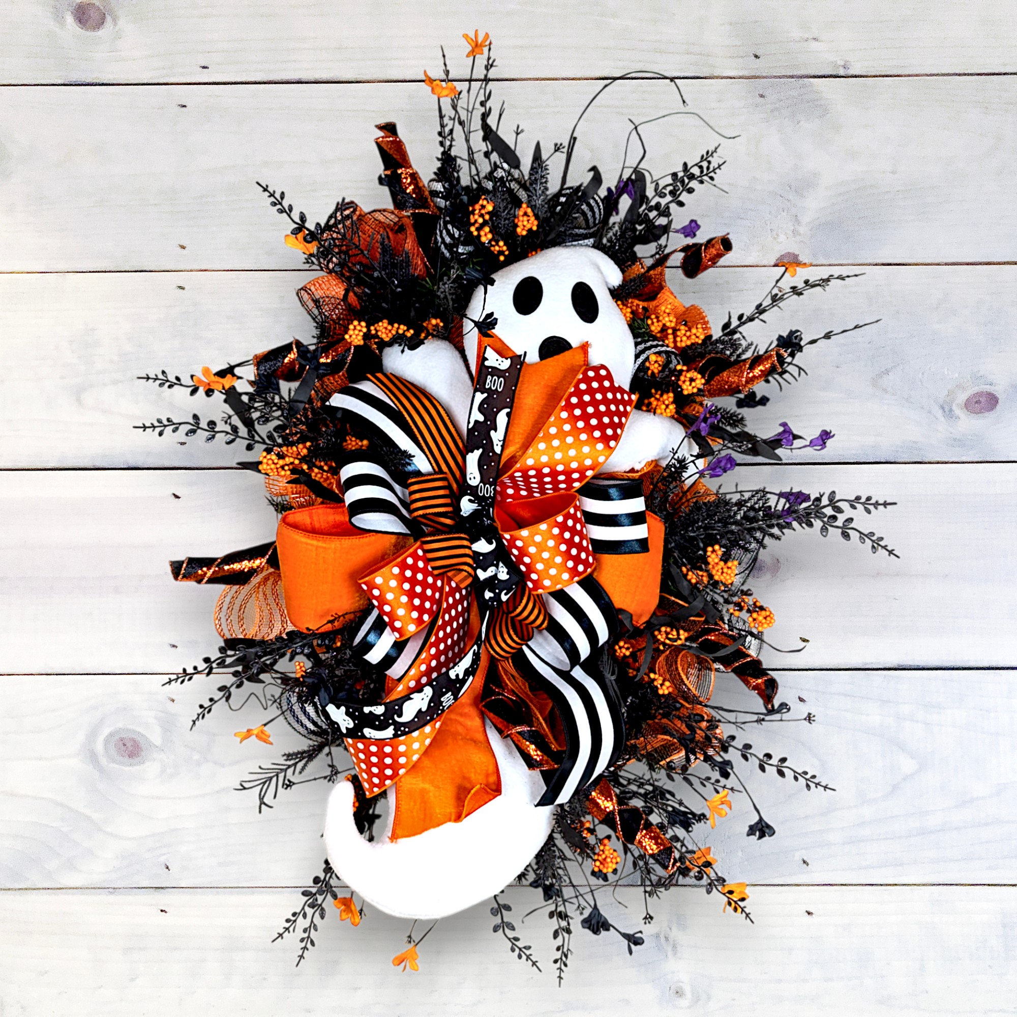 Handmade Halloween ghost wreath with orange, black, and striped bows, created for Jazz and Charm’s Halloween wreath-making class in Bakersfield.